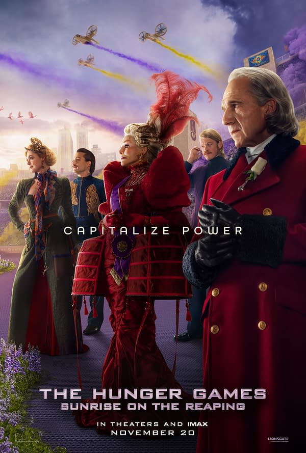 Promotional poster for The Hunger Games: Sunrise on the Reaping showing several Capitol figures in elaborate red and formal attire beneath aircraft trailing colorful smoke over a stadium. The title appears with the tagline