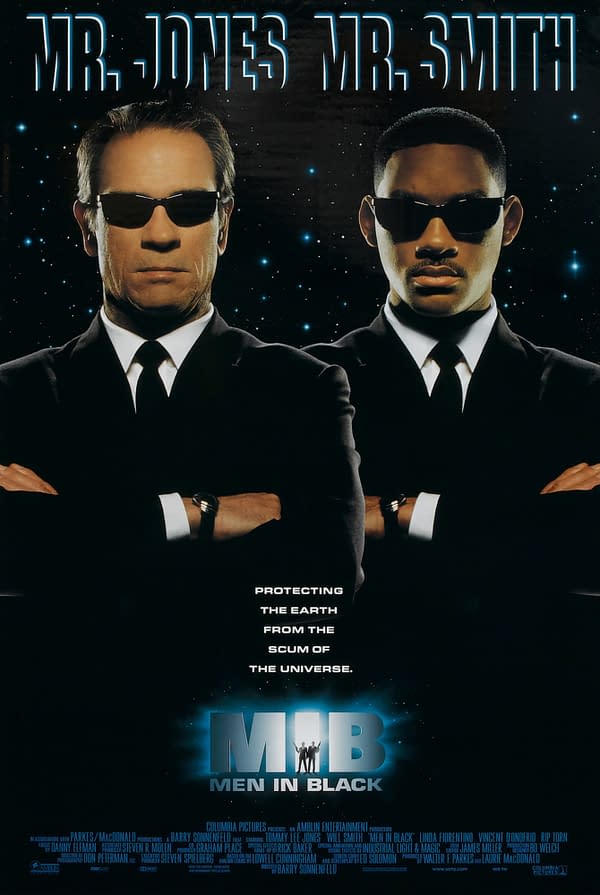 Film poster for 'Men in Black' featuring two men in black suits and sunglasses, standing back-to-back with arms crossed, against a starry background. Text above reads 'Mr. Jones Mr. Smith,' and below states 'Protecting the Earth from the scum of the universe.'