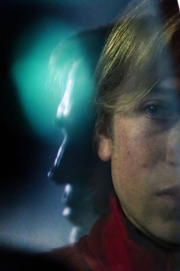 Close-up, moody portrait of a person with a blurred teal light in the background, likely from the Primetime series.
