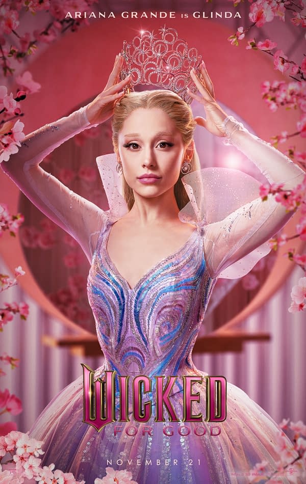 An illustration of Glinda, portrayed by Ariana Grande, elegantly wearing a sparkling crown and a shimmering, iridescent gown. The background features pink blossoms, enhancing the magical theme associated with the musical 'Wicked for Good,' set to release on November 21.