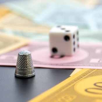Monopoly thimble, dice and money photo by CaseyMartin / Shutterstock.com.